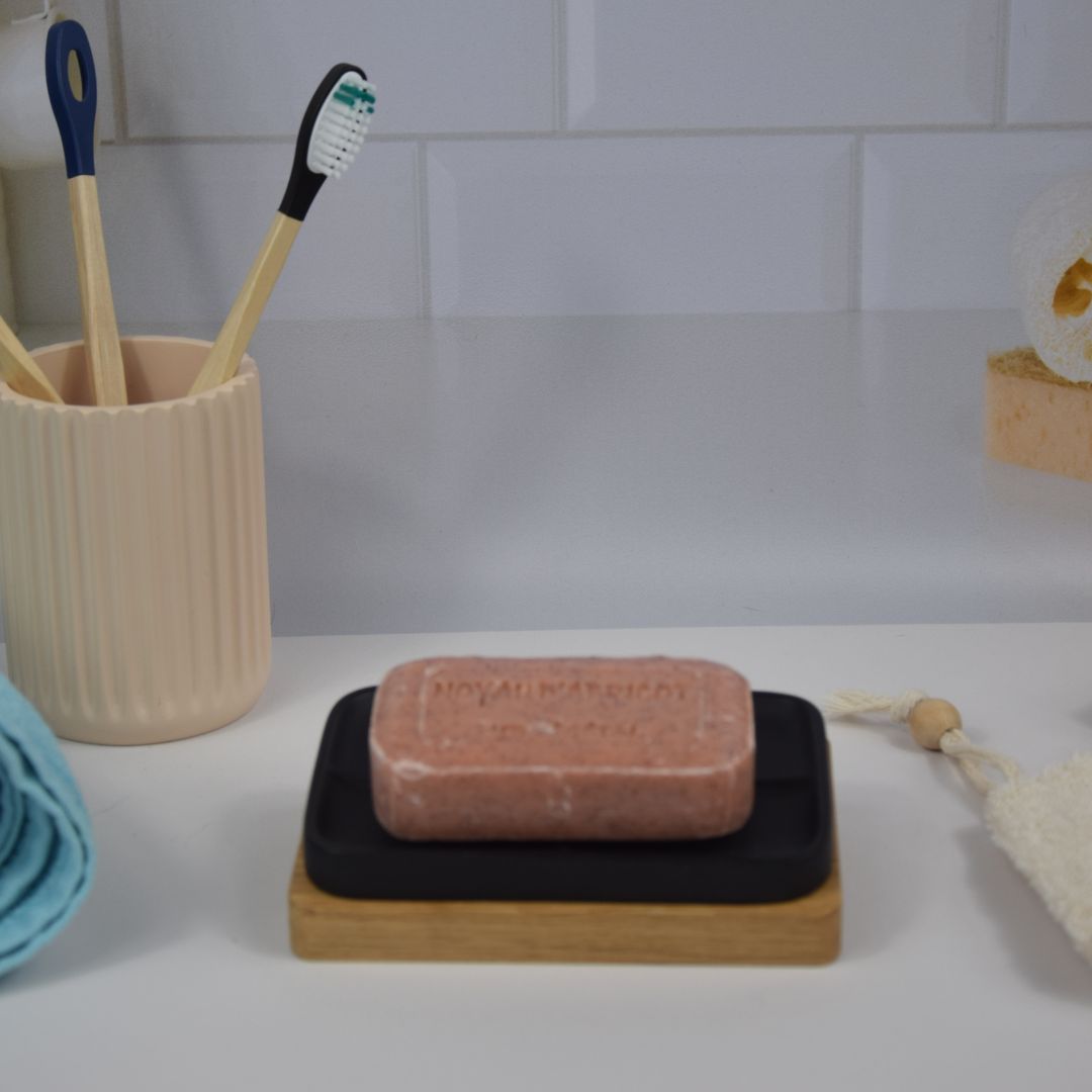 Savon à l'huile d'argan parfumé au noyau d'abricot, en arrière-plan une salle de bain.
