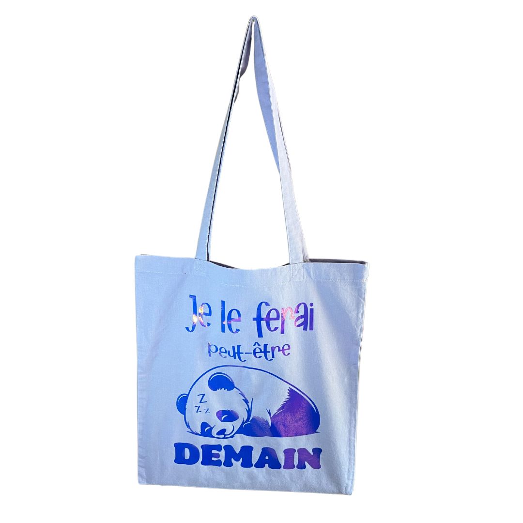 Tote bag bleu très clair avec panda bleu holographique posé sur un fond blanc.